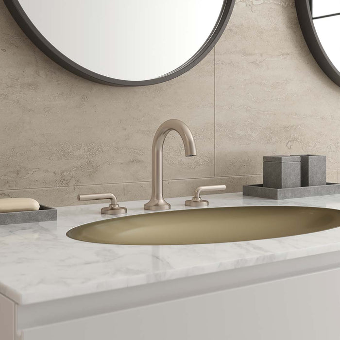 Pfister Tenet widespread vanity faucet in brushed nickel, installed on a marble countertop with a gold undermount sink and round mirrors.