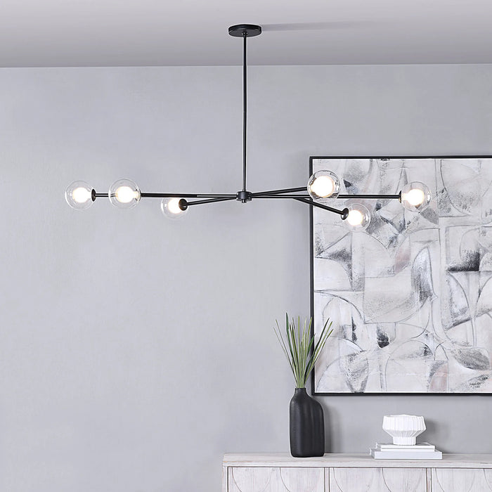 Modern black chandelier hanging in a room with abstract art and decor.