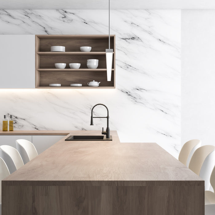 Minimalist kitchen with wood island, black faucet, marble backsplash, and white chairs.