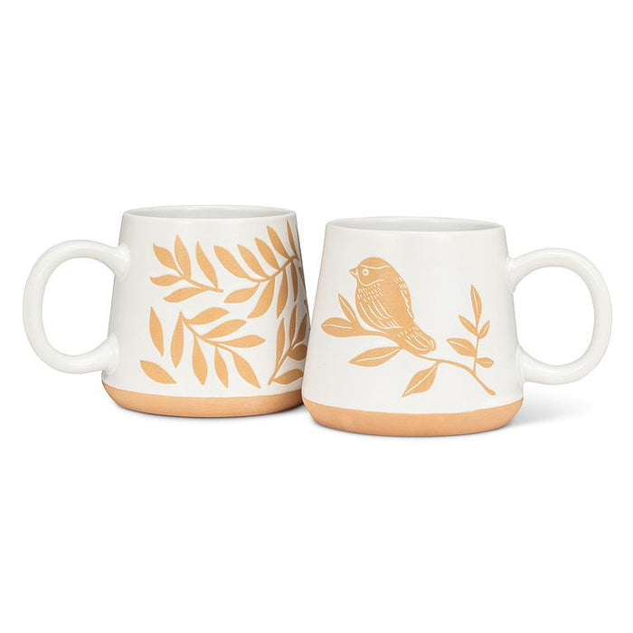 Two white mugs with gold leaf and bird designs on a white background
