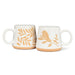 Two white mugs with gold leaf and bird designs on a white background