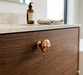 CBH 502 Classic Dome Cabinet Knob in bright bronze finish installed on a wood drawer