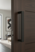 Close-up of a dark wooden door with a CBH handle in a modern interior setting.