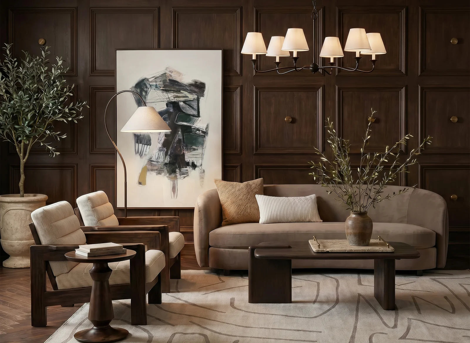 A styled living room interior featuring a beige sofa, two matching armchairs, a dark wood coffee table, a patterned area rug, dark wood paneled walls, and a large abstract painting.