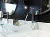 Pfister Contempra single-control vessel bathroom faucet in polished chrome, installed on a white modern marble countertop, with water flowing into a glass basin and round chrome-edged mirrors in a modern bathroom.