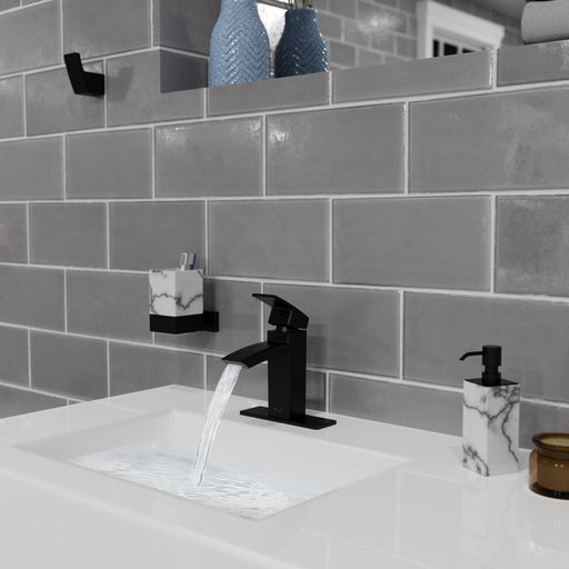 Pfister Kenzo faucet in matte black installed in a modern bathroom, showcasing a smooth water flow from the rectangular spout into a white sink.