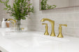 Pfister Rhen 2-handle 8-inch widespread bathroom faucet in brushed gold, installed on a white countertop in a contemporary bathroom.