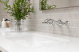 Pfister Rhen 2-handle wall-mount bathroom faucet in polished chrome, installed above a white undermounted sink on a clean, modern countertop in a contemporary bathroom.
