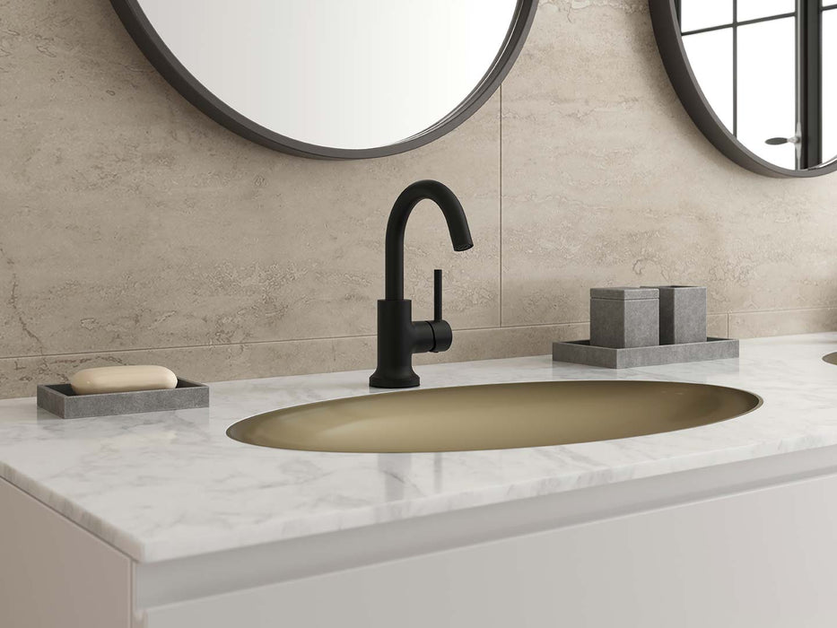 Pfister Tenet single-control bathroom faucet in matte black, installed on a white marble countertop with a matching gold sink, round mirrors, and minimalist decor.