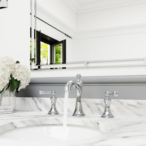 Pfister Tisbury 2-handle 8-inch widespread bathroom faucet in polished chrome, installed on a white marble countertop in a traditional bathroom, with water flowing smoothly from the curved spout.