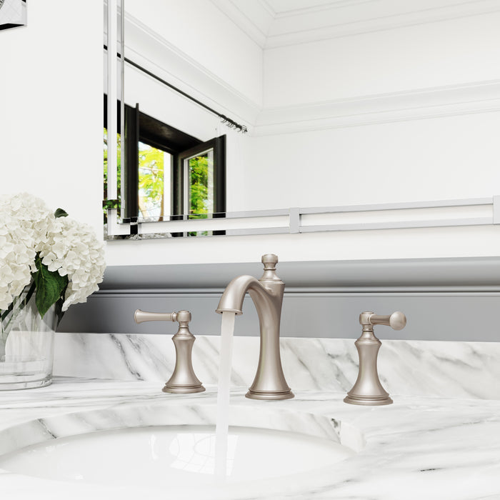 Pfister Tisbury 2-handle 8-inch widespread bathroom faucet in brushed nickel, installed on a white marble countertop in a transitional bathroom, with water gently flowing from the spout.