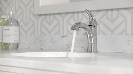 Pfister Weller single-control bathroom faucet in polished chrome, installed on a marble countertop in a contemporary bathroom with neutral-toned decor.