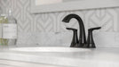 Pfister Weller 2-handle 4-inch centerset bathroom faucet in matte black, installed on a white marble countertop.