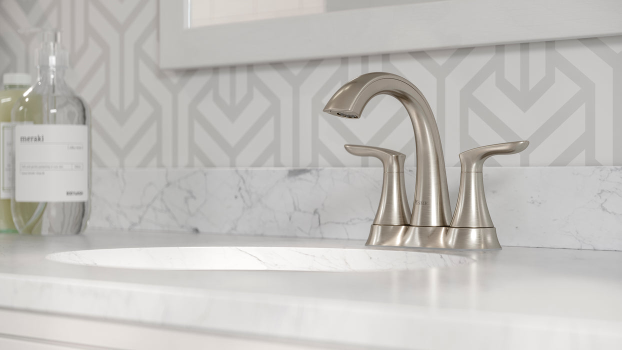 Pfister Weller 2-handle 4-inch centerset bathroom faucet in brushed nickel, installed on a white marble countertop.