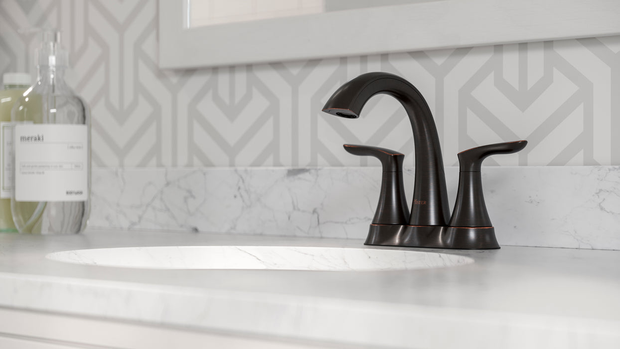 Pfister Weller 2-handle 4-inch centerset bathroom faucet in bronze, installed on a white marble countertop.
