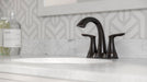 Pfister Weller 2-handle 4-inch centerset bathroom faucet in bronze, installed on a white marble countertop.