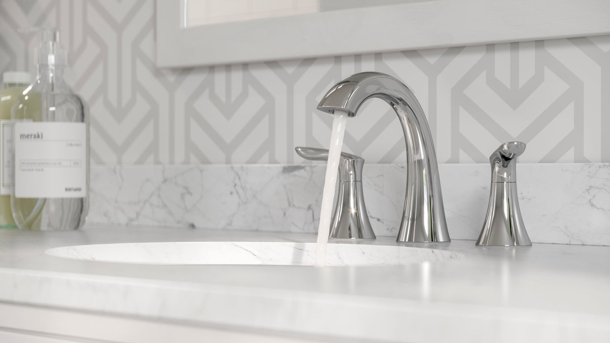 Pfister Weller 2-handle 8-inch widespread bathroom faucet in polished chrome, installed on a white marble countertop in a modern bathroom, with water flowing smoothly from the spout.