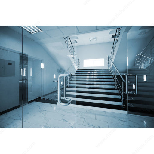 Richelieu 872RO offset round tubular pulls in stainless steel installed on commercial glass doors showing back-to-back mounting and curved form.