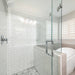 Richelieu 87D2S square tubular pull for glass doors, installed view in stainless steel on clear glass shower door.