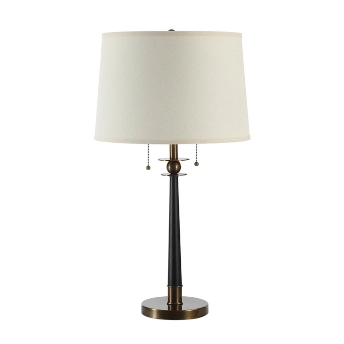 Table lamp with a white shade and black and bronze base on a white background
