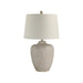 Table lamp with textured ceramic base and white shade on a white background