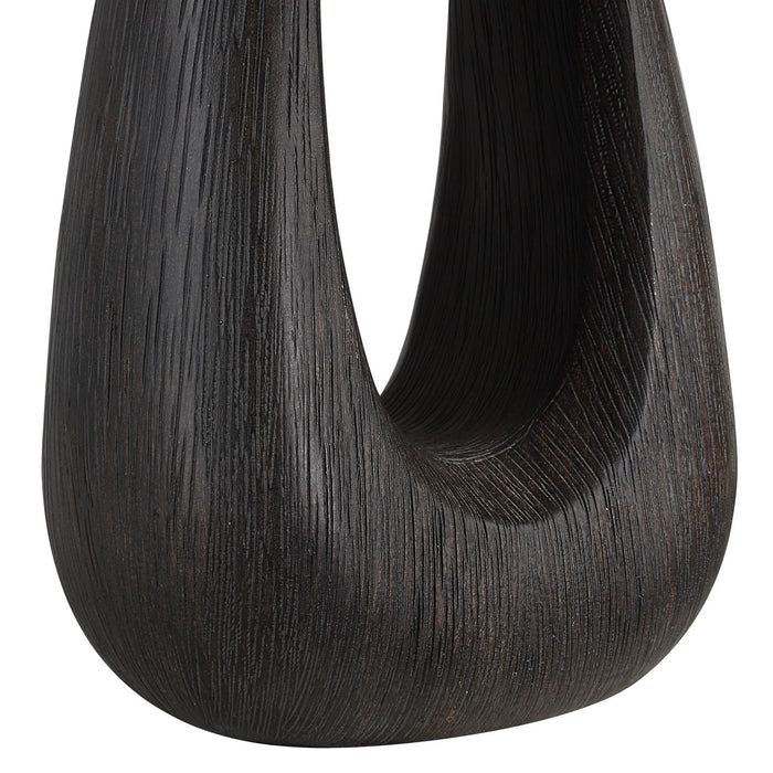 Dark sculptural wood table lamp on a white background