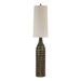 Decorative floor lamp with a textured base and oatmeal shade on a white background