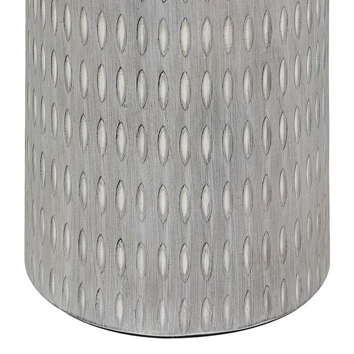 Close up view of a cream floor lamp with a textured pattern on a white background