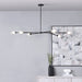Modern black chandelier hanging in a room with abstract art and decor.