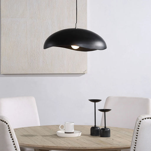 Black pendant dome light hanging above a dining table with white chairs.