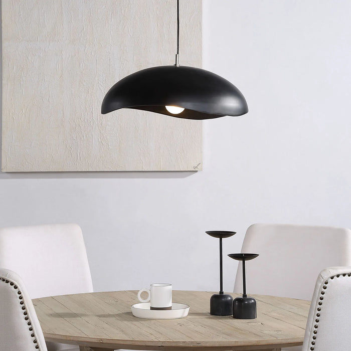 Black pendant dome light hanging above a dining table with white chairs.