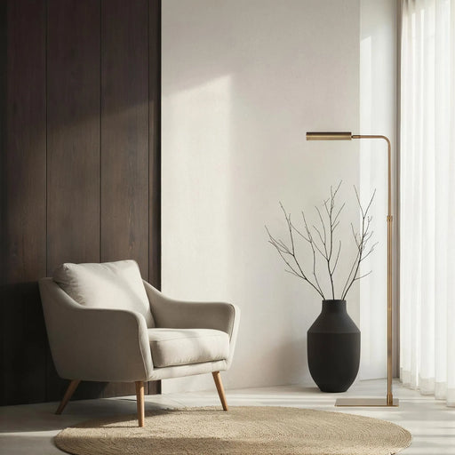 Modern interior with a beige armchair, black vase with branches, and reading floor lamp.