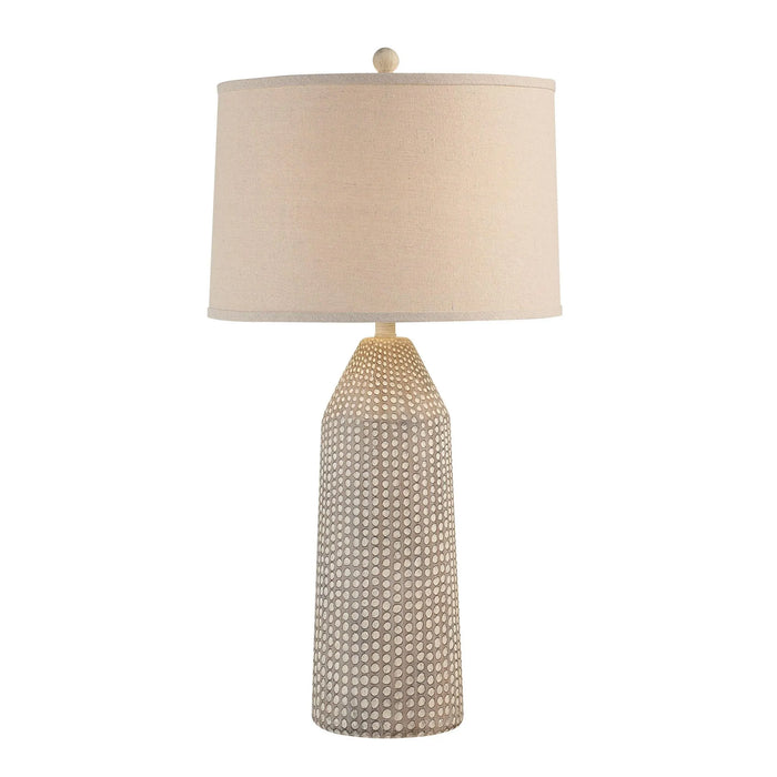 Table lamp with textured base and beige lampshade on a white background