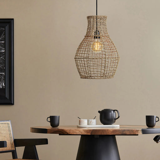 Woven pendant light hanging above a wooden table with black chairs and decor items.