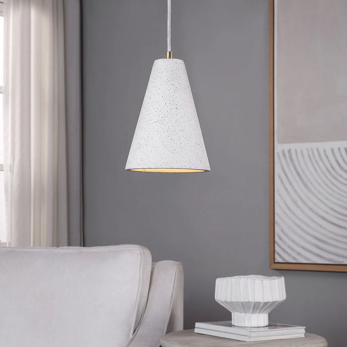 White textured pendant light hanging in a room with a gray wall, white sofa, and framed artwork.