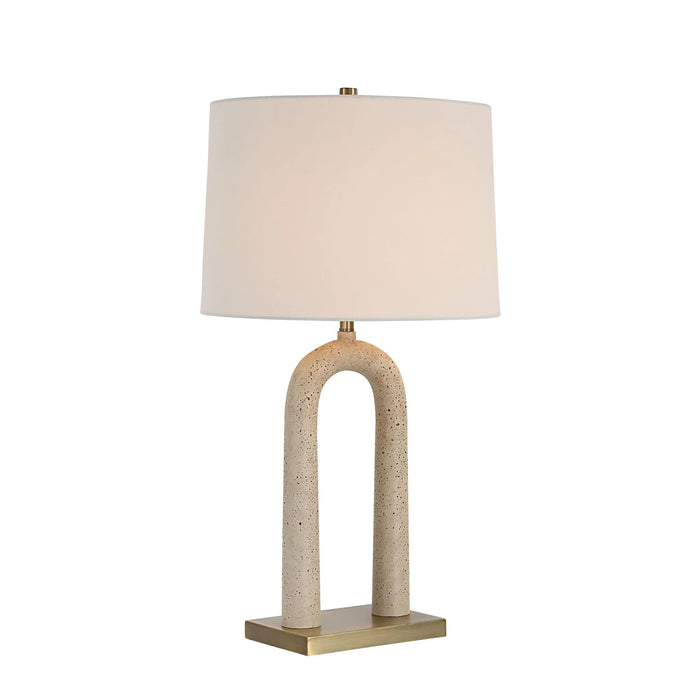 Table lamp with beige travertine finish and antique brushed brass base on a white background