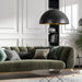 Modern living room with a green sofa, black pendant lamp, and decorative pillows.
