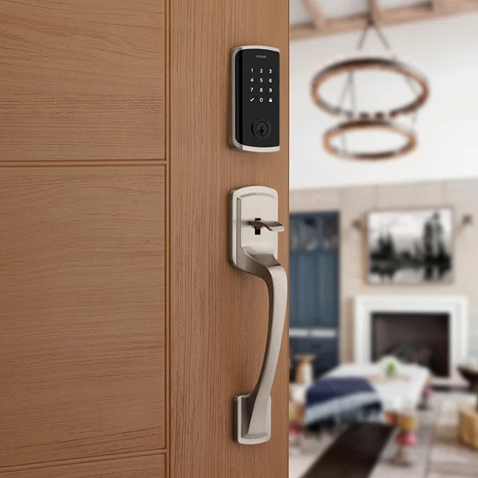 Smart door handle and lock on a wooden door with a blurred living room in the background