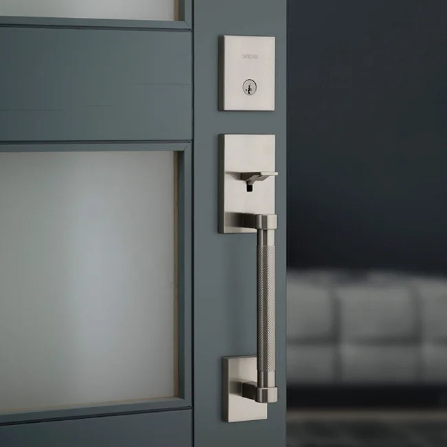 Modern door handle and lock on a gray door with a blurred background