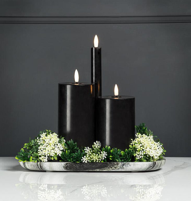 Black marble tray styled with pillar candles and greenery