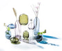 Abbott coloured glass vases arranged with flowers and decorative accents on a tabletop