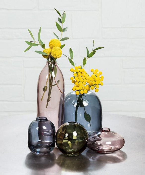 Abbott dark blue glass bud vase styled with yellow flowers in a decorative home setting