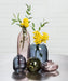 Abbott dark blue glass bud vase styled with yellow flowers in a decorative home setting