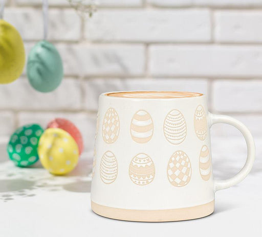Ivory and sand patterned egg mug styled with colourful Easter eggs