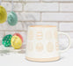 Ivory and sand patterned egg mug styled with colourful Easter eggs