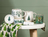Abbott pinecone stoneware mugs displayed with evergreen trees and seasonal décor