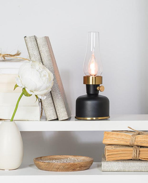 Small black lantern LED lamp displayed on a shelf with decorative home accents