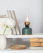 Green rechargeable lantern LED lamp displayed on a shelf with decorative home accents