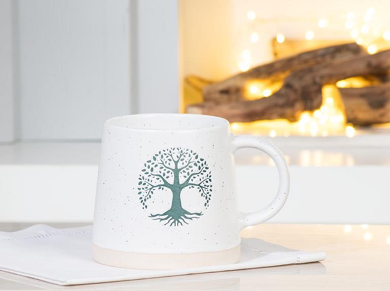Ivory and green Tree of Life mug styled with coffee in a bright kitchen