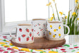 Abbott lemon stoneware mugs displayed on a tray with spring flowers and colorful table décor